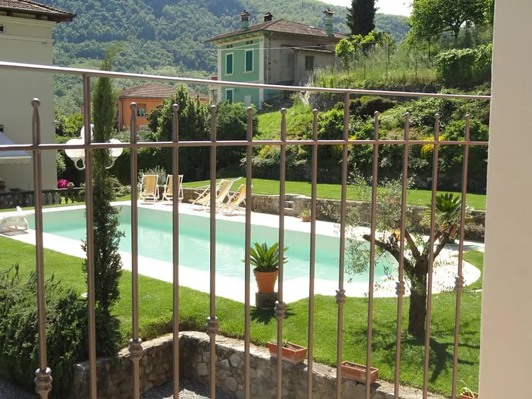 Ringhiera in ferro a bordo di una piscina, con le colline sullo sfondo